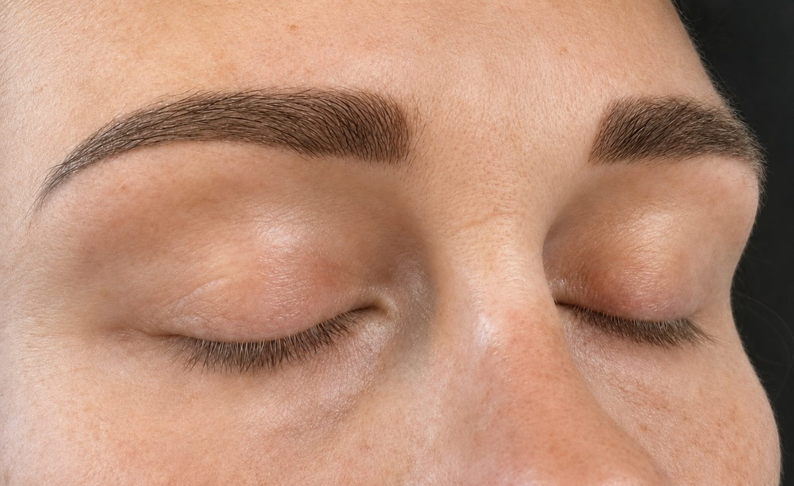Close-up van zachte, natuurlijk gevulde Powder Brows met gesloten ogen